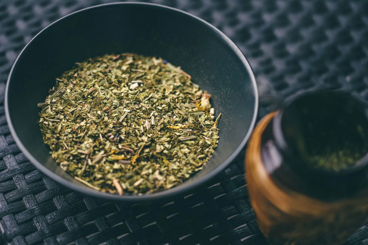 Beramā yerba mate tumšā bļodā līdzās koka kalabasei